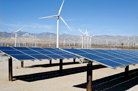 Solar panels and wind turbines in the desert.