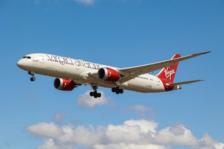 A Virgin Atlantic Airways Boeing 787 in blue skies beneath white clouds.