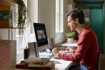 Casually dressed male working from home having virtual meeting.