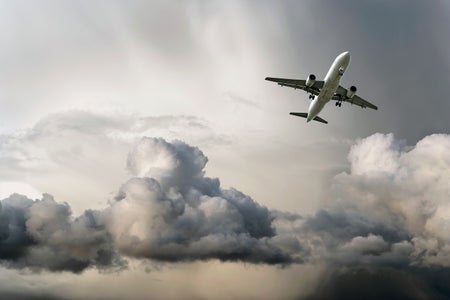 A plane flies above clouds