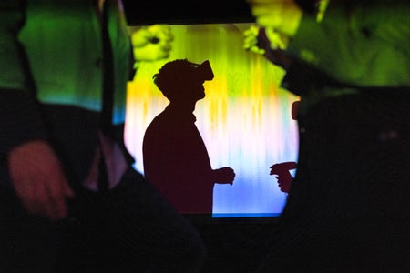 Side view of person watching through virtual reality glasses in exhibition center