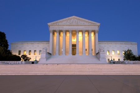 Supreme Court Building with blue skies and illuminated interior/soft pink stairs