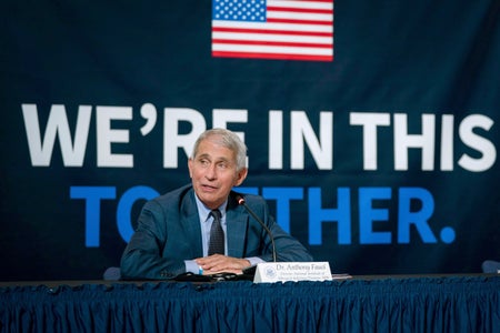 Dr. Anthony Fauci in front of backdrop that reads "We're in this Together"