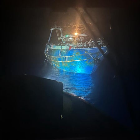 Overcrowded fishing boat in dark waters on Greek coast