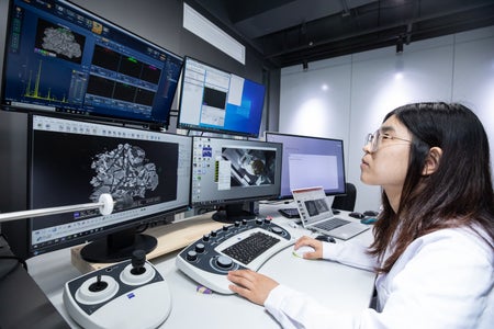 A female Chinese scientist looks at a computer screen.