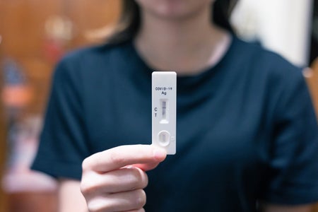 Close-up shot of woman's hand holding a negative test device.