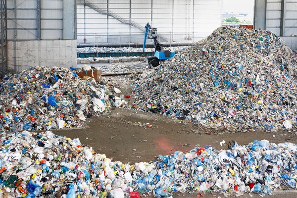 Towering piles of discarded items and packaging at a New York City recycling center processing plant