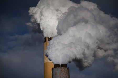 Dirty smoke coming out of two smokestacks on coal fired plant.