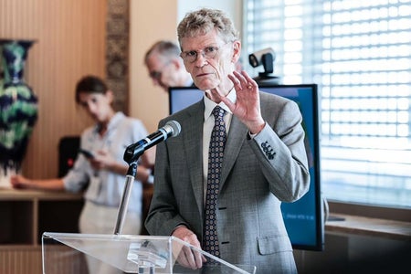 An interior of a man speaking at a podium.